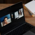 Dwie osoby siedzące przy laptopie podczas zdalnej sesji edukacyjnej