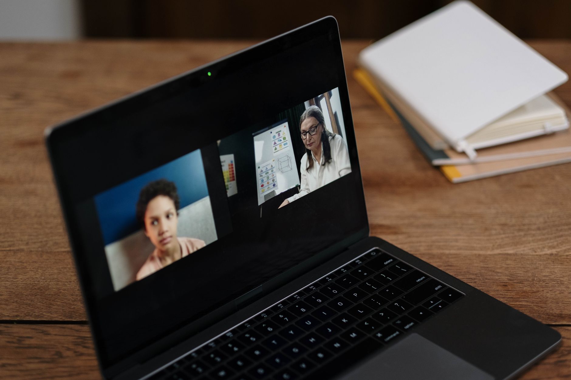 Dwie osoby siedzące przy laptopie podczas zdalnej sesji edukacyjnej