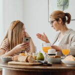 Mama rozmawia z nastoletnią córką przy śniadaniu przy stole