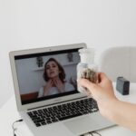 Pacjent pokazuje lekarzowi suplementy podczas wideokonsultacji na laptopie
