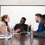 Zespół różnych specjalistów dyskutuje przy biurku w sali konferencyjnej